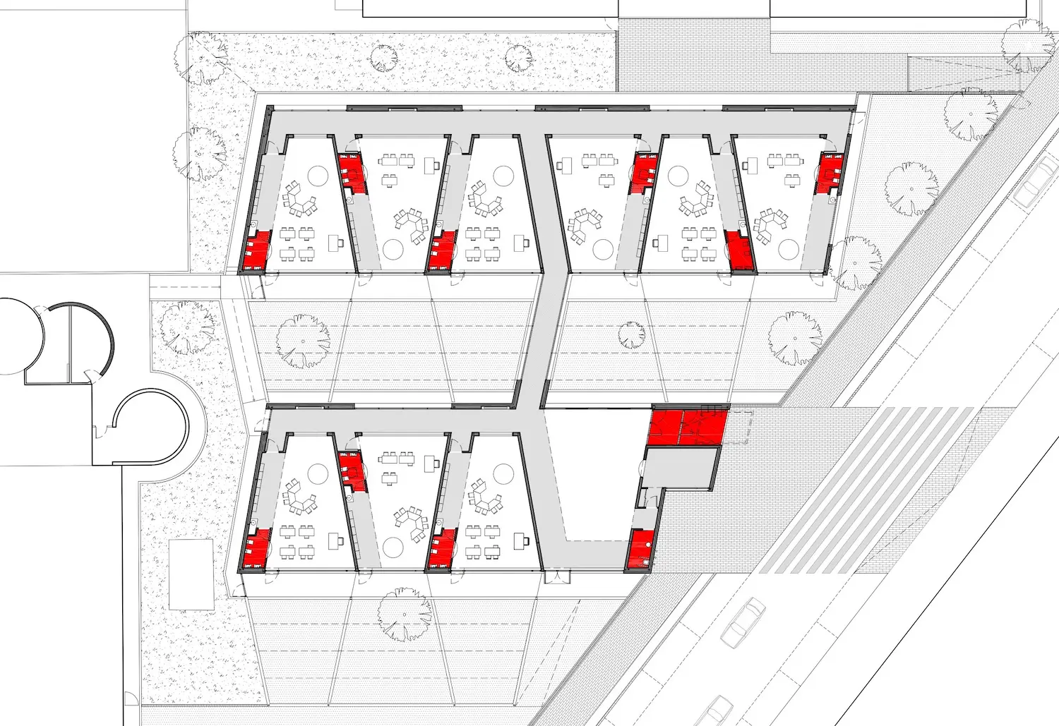 Plano arquitectónico que muestra seis salas dispuestas en dos filas, cada una con escritorios y sillas. Algunas paredes están marcadas en rojo, probablemente para indicar puertas o ventanas. Las zonas circundantes muestran caminos, árboles y calles cercanas.