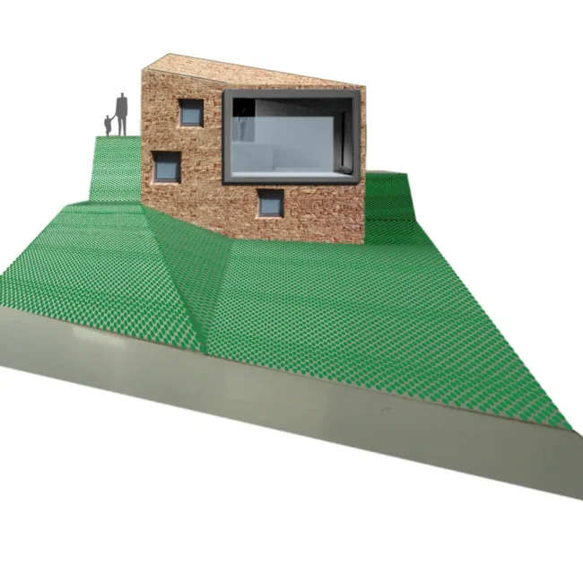 Una casa moderna con paredes de textura de piedra y diseño cuadrado se asienta sobre un modelo de terreno verde, inclinado y cuadriculado. Una silueta humana se sitúa cerca de la casa para dar sensación de escala.